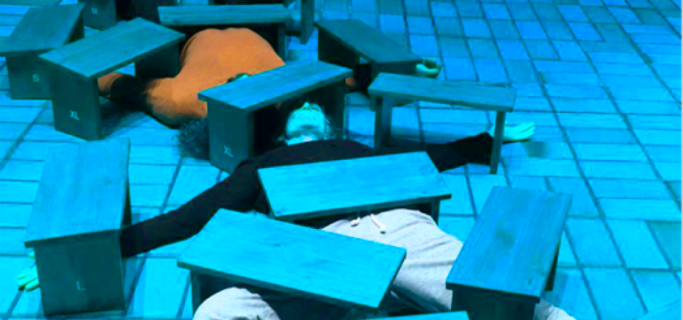 Zwei Körper liegen unter vielen Holzbänkchen, so dass nur ein Oberkörper in orange sowie Beine in beige erkennbar sind. Der Boden ist von Kacheln durchzogen und das Bild schimmert in einem blauton. s 